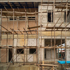 Under construction home or house with scaffolding on site in village. Old unfurnished rental property, living space units. lifestyle. Renovation.