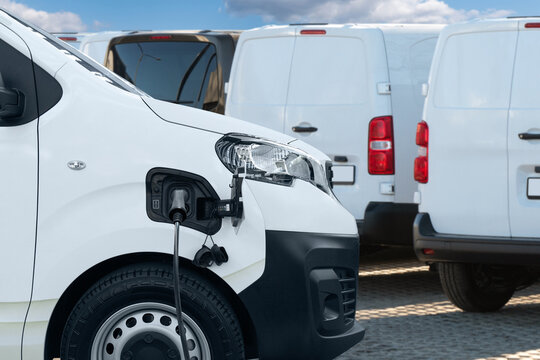 Fototapeta Electric delivery vans with electric vehicles charging station