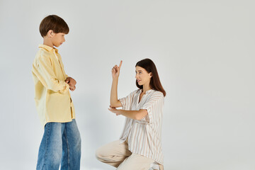 A mother patiently engages her hearing impaired son, fostering understanding and connection.