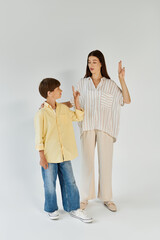 A little boy with hearing impairment engages in sign language with his mom, showcasing connection.