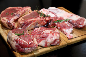 Raw aged steak. A raw, aged steak on a wooden board awaits to be cooked.