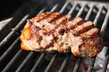 Cooking steak on the grill and coals. Roasting steak in a restaurant.