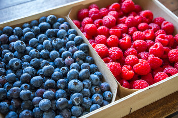 Wooden crate filled with blueberries and raspberries