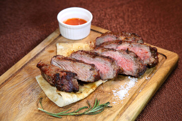 Steak placed on pita bread on a special wooden board. Beef steak on a wooden board.