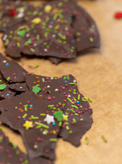 Festive chocolate bark topped with Christmas sugar sprinkles, including trees, gingerbread men, stars, and red decorations. A sweet treat perfect for holiday celebrations