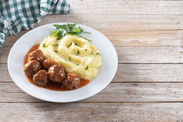 Meatballs with mashed potatoes on wooden table. Copy space