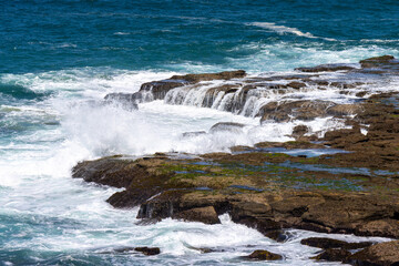 Waves crashing on a rock ledge