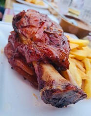 Pork shank cooked at restaurant with fried potatoes