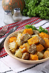 Baked pork with potatoes and pumpkin, homemade hearty dish. Closeup