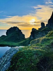 Majestic cliffs silhouetted against a vibrant sunset, overlooking the calm sea below