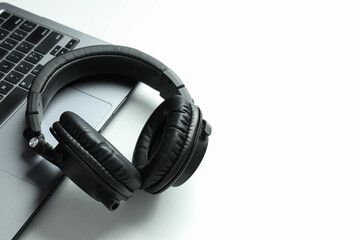 Big headphones, on a table with a laptop.