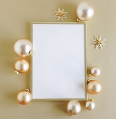 Gold frame blank mockup with copy space top view and gold Christmas decoration on golden background...