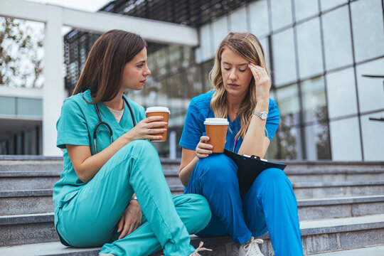 Two Nurses Taking a Break With Coffee Outside Hospital