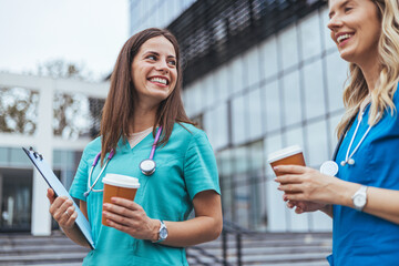 Smiling Nurses Enjoying Coffee Break Outside Hospital Building