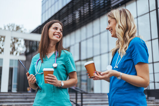 Two Healthcare Professionals Enjoy Coffee Break Outside Clinic