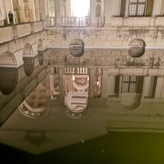 Palazzo Te building in Mantua reflecting in the water at night, creating a surreal illusion