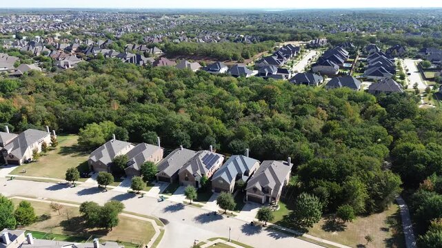 Net zero green community upscale neighborhood row of suburban houses dense tree forest, well-trimmed landscape in Bartonville and Argyle, Denton County, Texas, water tower background flyover