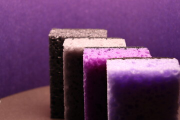 stylish dark sponges for washing dishes and cleaning on a purple background