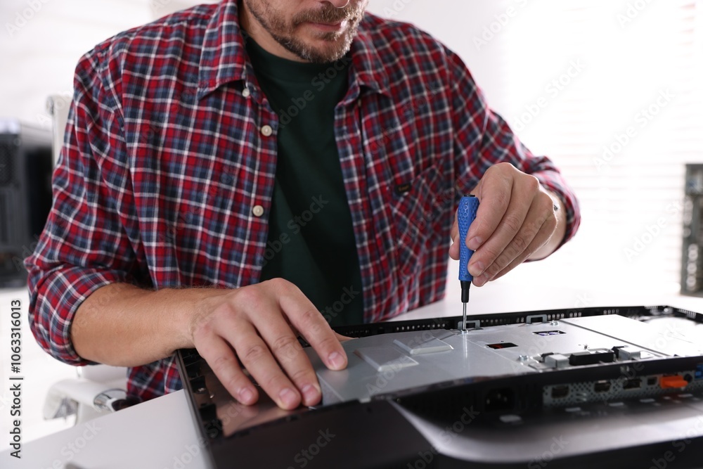 Poster man fixing computer monitor at white table, closeup