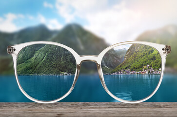 Glasses against beautiful landscape. View through lenses more clear. Vision correction