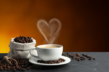 Fresh aromatic coffee and beans on table, space for text. Steam in shape of heart over cup