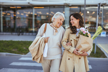 Happy Senior Woman and Daughter Carrying Groceries Outdoors