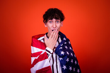 A funny young attractive guy with a curly hairstyle poses in the studio.