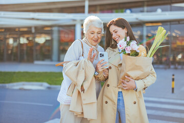 Two Women Sharing a Joyful Moment Outside Shopping Center