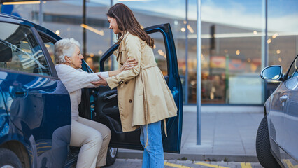 Young Woman Assisting Elderly Woman Out of the Car