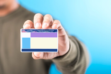 Thai man holds a blank Smart Card Thailand driver's license, emphasizing the importance of obtaining a license for road safety and responsible driving