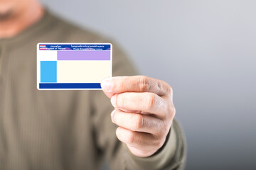 Thai man holds a blank Smart Card Thailand driver's license, emphasizing the importance of...