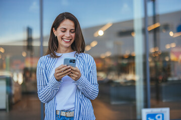 Cheerful Woman Texting Outside Modern Shopping Mall