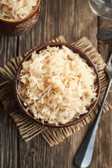 Homemade fermented cabbage or sauerkraut in a pot on a table, top view