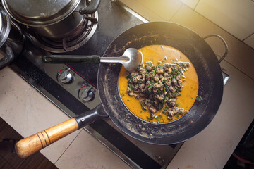 Thai Curry with River Snail. Fresh snail meat in spicy thick soup fresh coconut milk add cha-om and betel leaves in a pan on the gas stove that has just been cooked. the kitchen home cooking style.