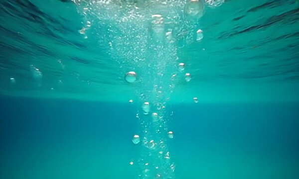 Underwater slow motion bubbles moving to surface in turquoise crystal clear pool