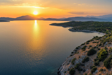 Obraz premium Aerial Coastal Sunset Over Rocky Mediterranean Shoreline with Silhouetted Islands, Vibrant Sky Reflections, and Ethereal Lighting