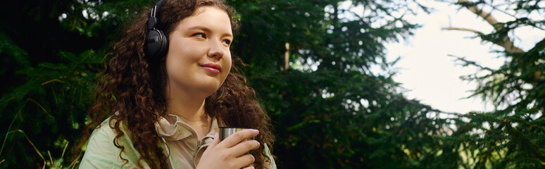 The plus size woman savors a tranquil moment in a lush green forest, lost in music and thought.