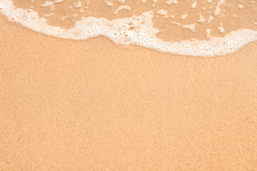 White Soft wave of sea ocean on sandy beach Background.Top view Sand Texture Brown Beach sand dune for Summer banner background.Sunny on water soft sand, calm, tranquil relax with sunlight