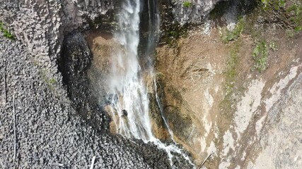 Aerial view of a waterfall cascading down a rugged cliff side in the Pacific Northwest, Washington State.