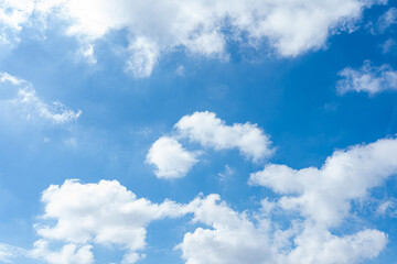 Naklejka premium Fluffy cumulus clouds drift across a vibrant blue sky