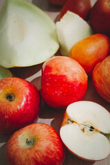 Ripe red apples and ripe melon lie in a heap on the table. Vertical photo.