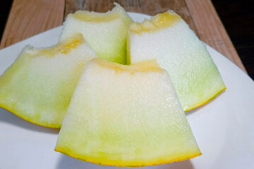 Delicious, juicy Melon sliced on a plate. Close-up, vertical photo.
