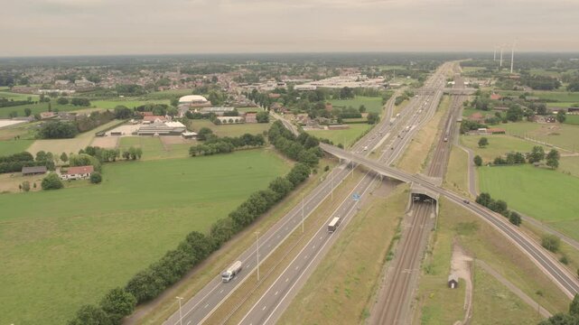E19, Brecht, Antwerpen, Belgium, 15th of June, 2024, A breathtaking aerial view displays an extensive highway intertwined with lush green fields and diverse urban areas