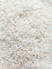 A closeup shot of uncooked white rice grains, showcasing their elongated shape and textured surface