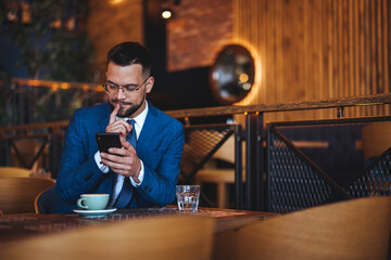 Businessman Engaged With Smartphone in a Modern Coffee Shop