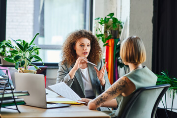 Two coworkers passionately exchange ideas in a welcoming office, highlighting their teamwork.