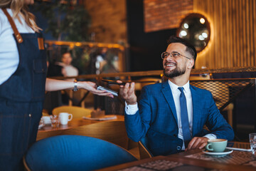 Businessman Paying with Smartphone in Modern Cafe Setting