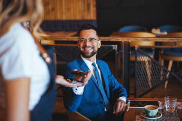 Confident Businessman Enjoying Coffee Break in Modern Cafe