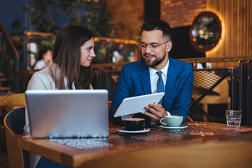 Business Colleagues Discussing Project Over Coffee in Modern Cafe