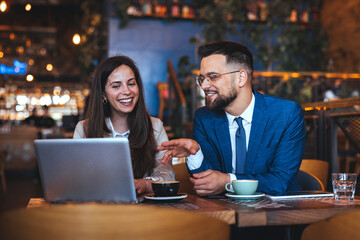 Colleagues Enjoy Lively Discussion Over Coffee At Cafe